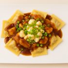 Ravioli poutine Morini servi avec sauce brune, fromage en grains et oignons verts