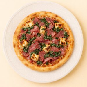 Pizza garnie de smoke meat en carpaccio, halloumi grillé et chimichurri sur pâte cuite au four