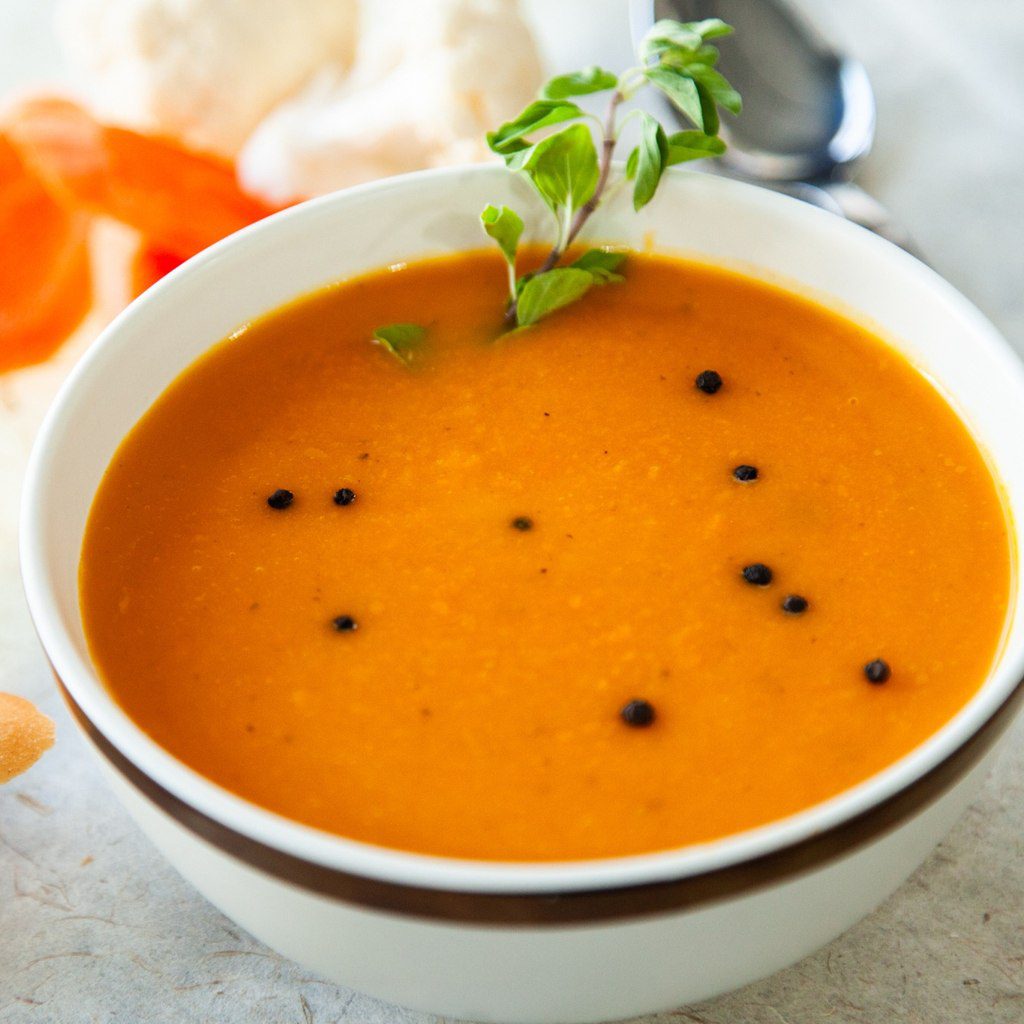 Bol de potage Crécy à la carotte avec notes de gingembre, texture veloutée et garniture légère.