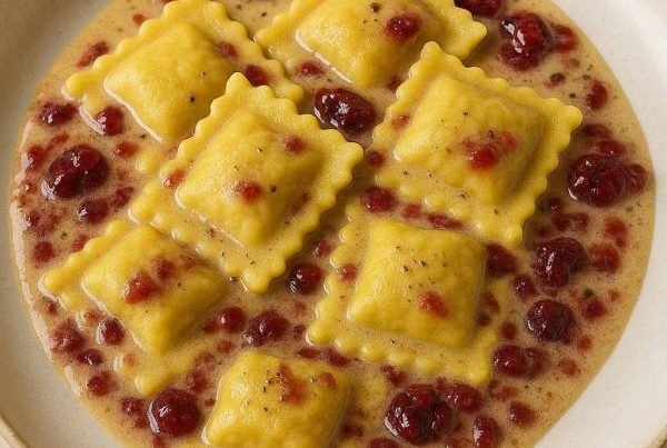 Plat de ravioli au canard confit servi avec une sauce au poivre et canneberges, présentation style restaurant étoilé.