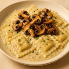 Assiette de raviolis nappés de sauce aux champignons avec champignons sautés, plat crémeux et gourmand Morini Pasta.