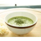 Crème de brocolis aux fines herbes servie dans un bol avec fromage râpé